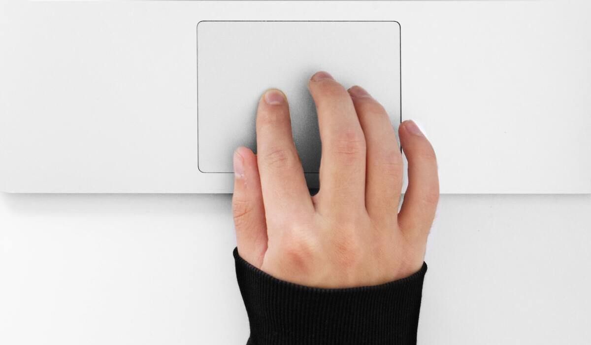 Hand doing gestures on MacBook Trackpad