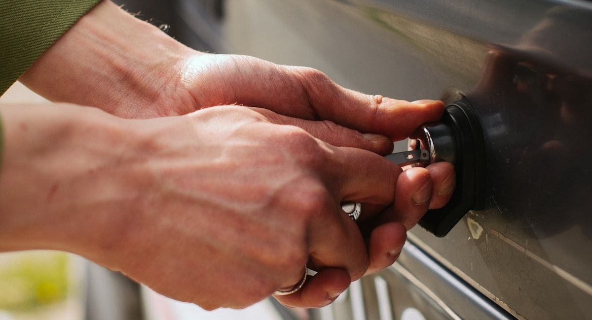 Hands of a Man Unlocking a Lock